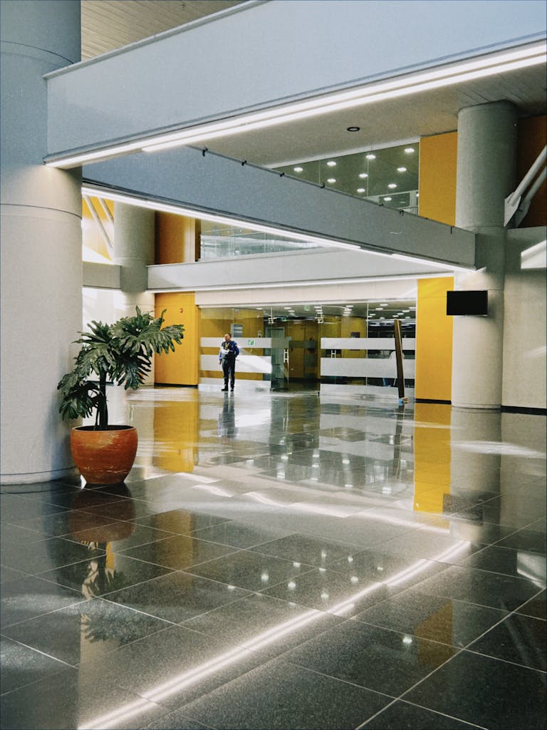A contemporary indoor lobby space with a glossy floor and modern architectural elements.